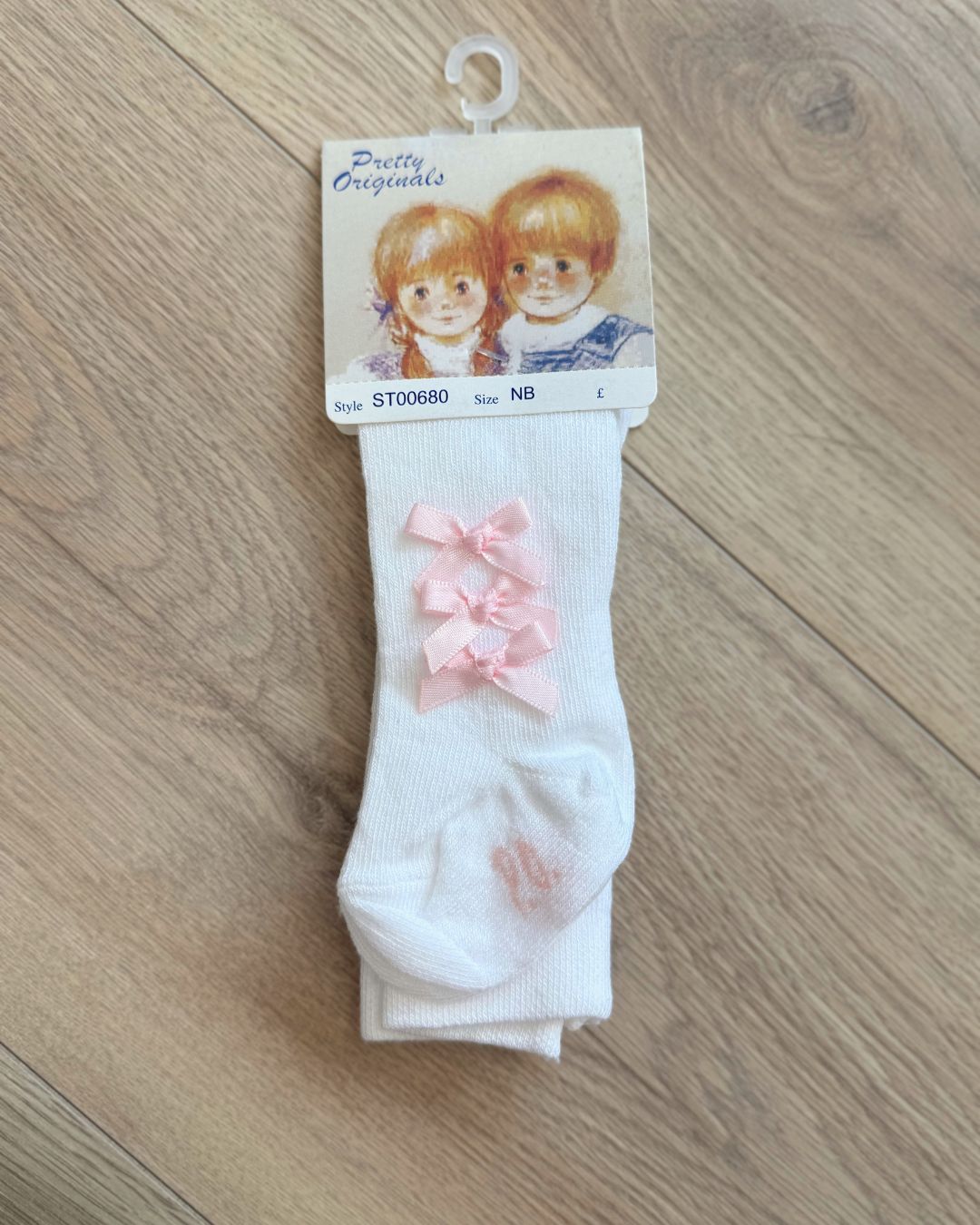 Pretty Originals white girls tights with three pink bows running down the outer sides.