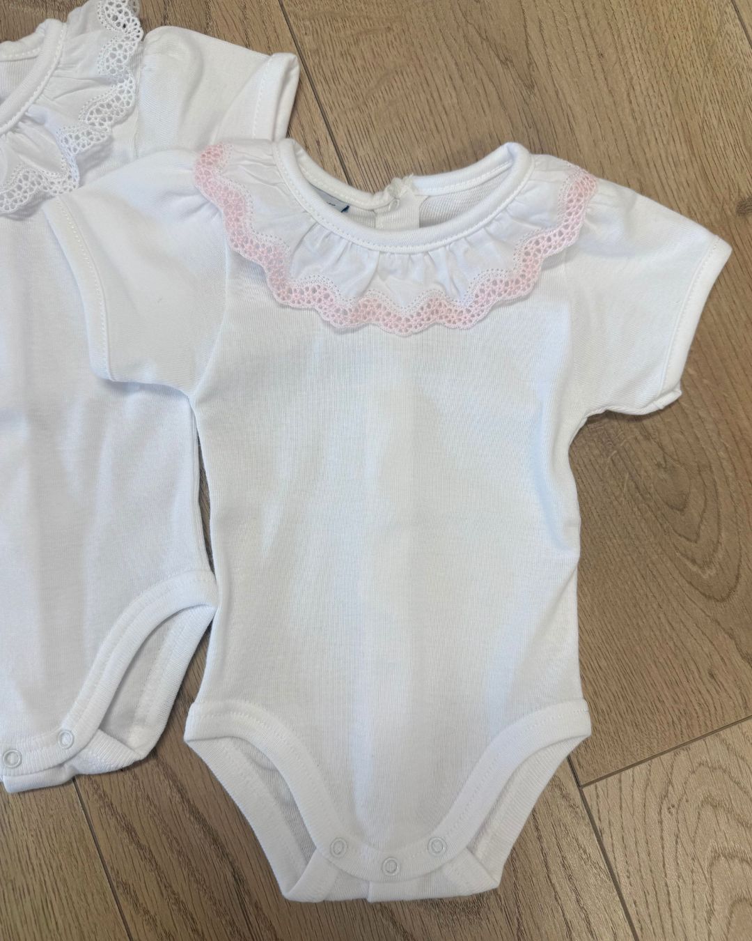Babidu white short sleeve baby vest with lace frill collar in pink or white trim.