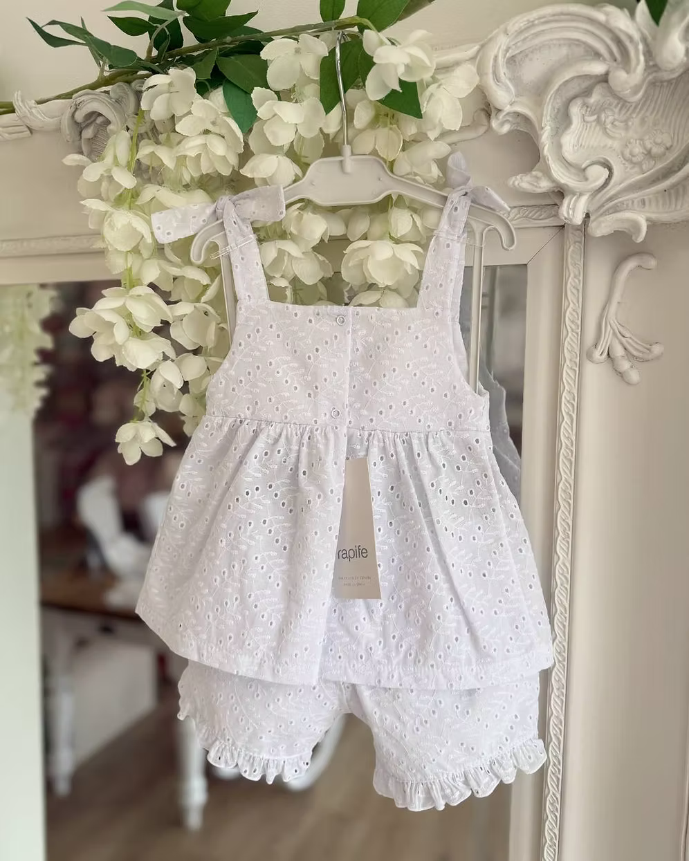 white broderie anglaise floaty top with matching frill trim shorts and shoulder ties