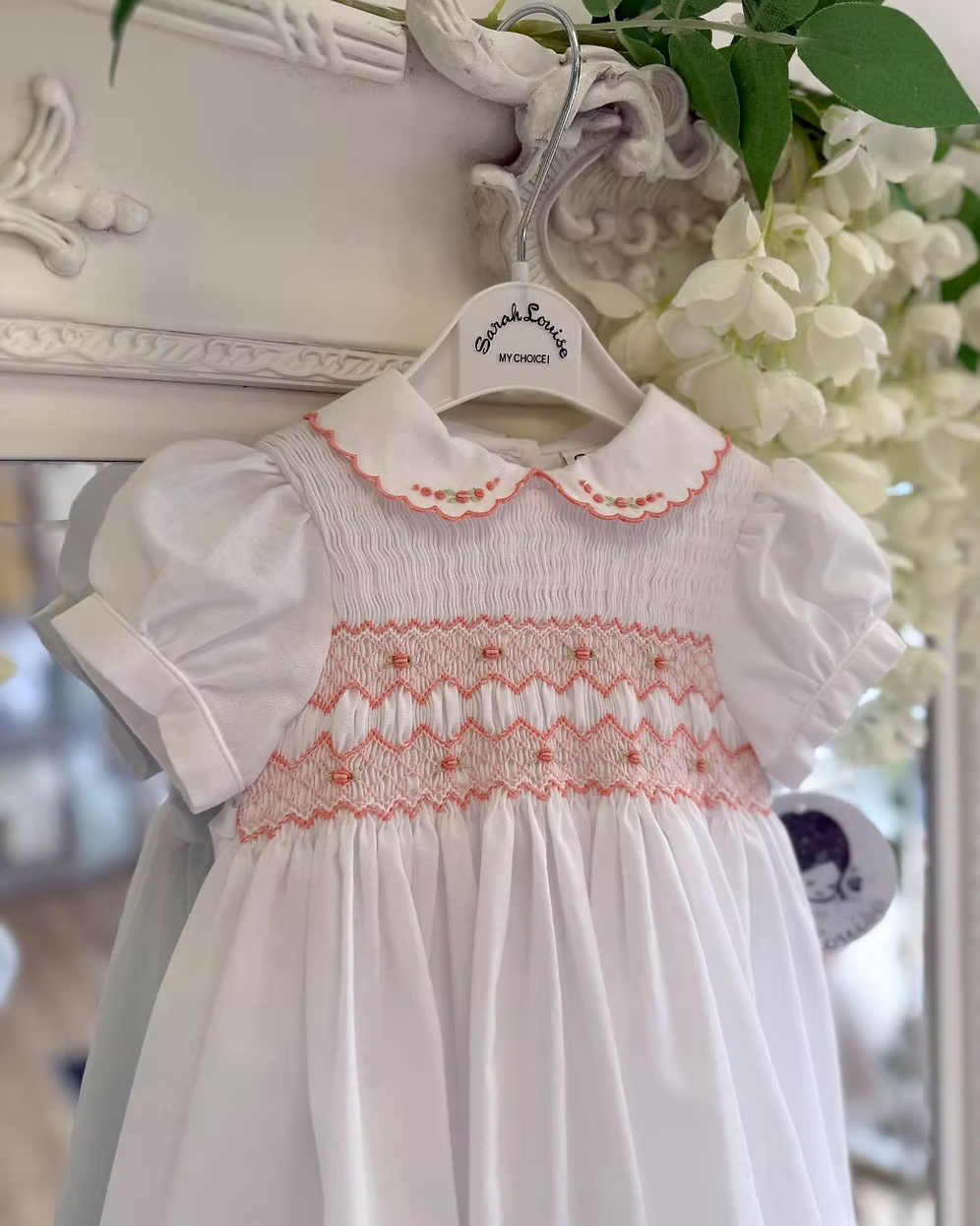 White smocked dress with peach smocking, embroidered florals and scalloped hems
