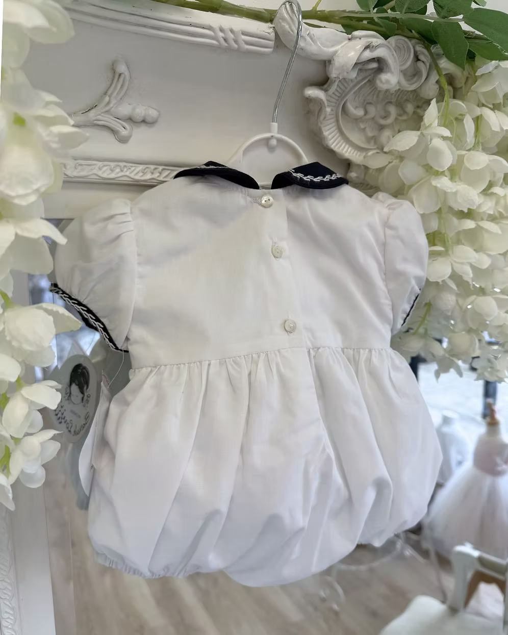 back of the white bubble romper with button fastening