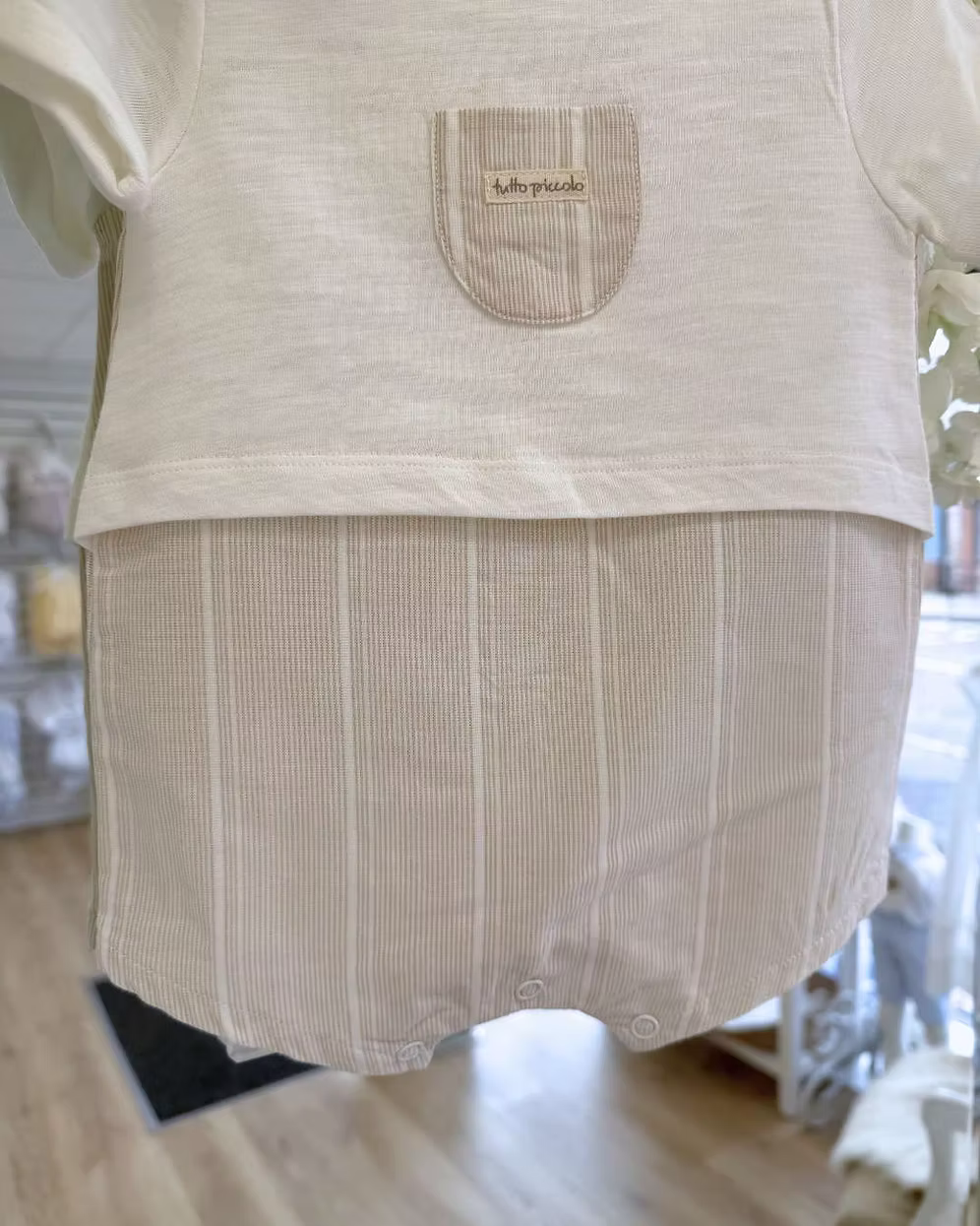 Tutto Piccolo Finn Romper featuring an ivory top, beige striped lower half, chest pocket with embroidered logo and lightweight summer design.