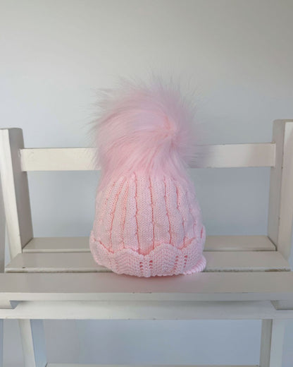 Little Nosh Aurora pink knitted baby girls winter hat with faux fur pom pom, scalloped hem and cosy ear covers.