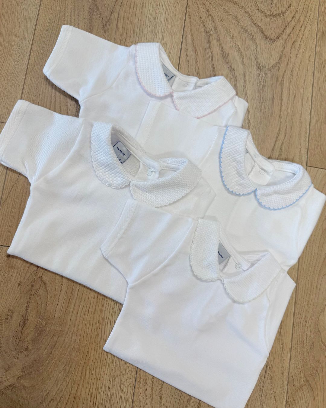 Babidu white unisex baby bodysuit with Peter Pan collar and coloured stitch trim.