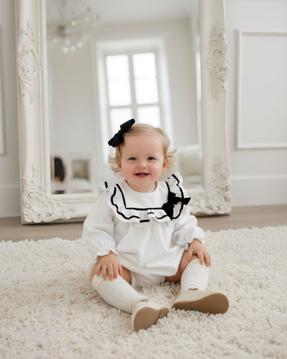 Fofettes X Be Chic Alba white velvet baby girls romper with sailor frill collar, black trim and velvet bow.