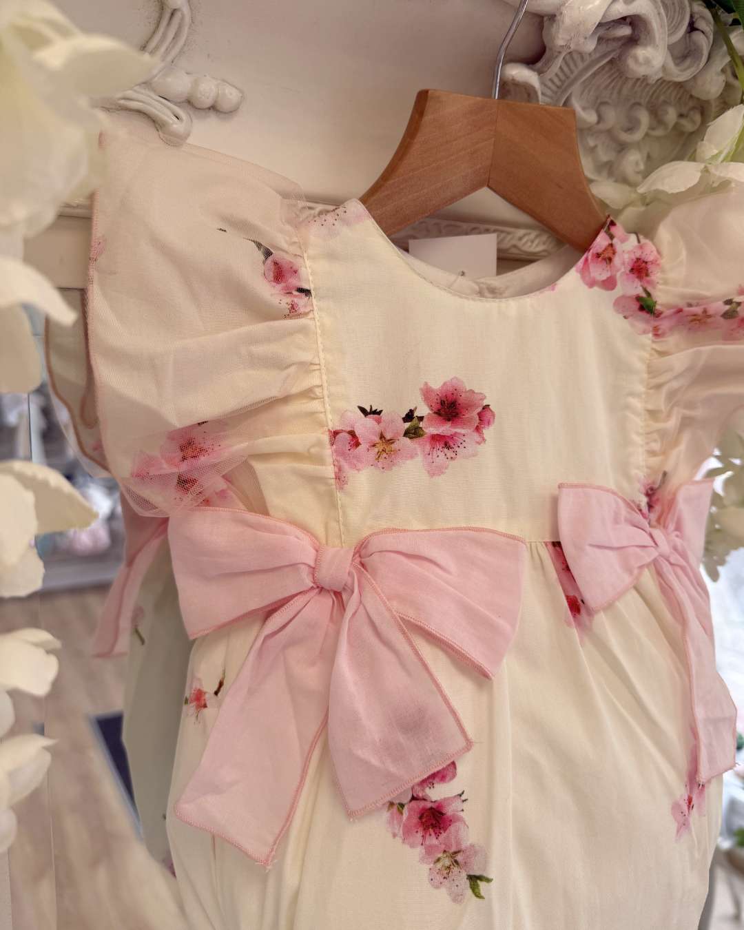Phi lemon bubble romper with a pink cherry blossom print and two large pink bows on the waist