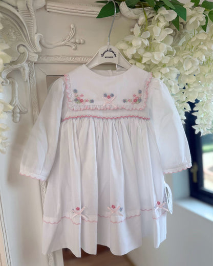 Sarah Louise Evelyn white girls smocked dress with pink and blue floral embroidery, square frill collar, satin bows and bow back tie.