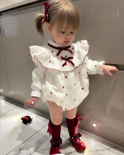 Phi Juliet ivory baby girls romper with red polka dots, frilled collar and red velvet bows.