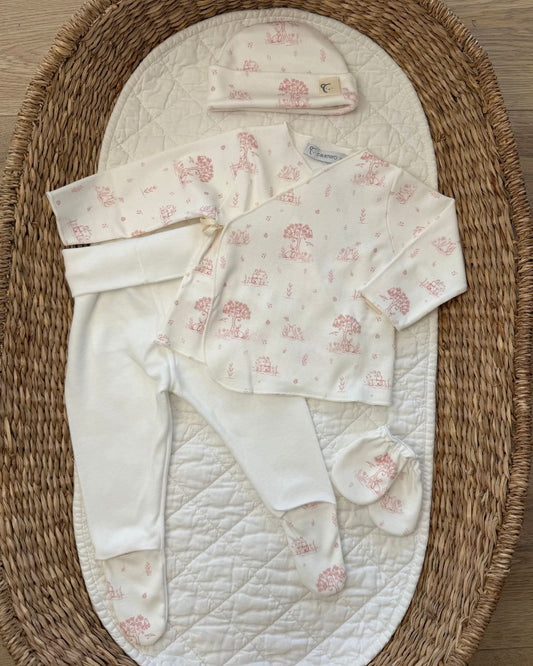 Calamaro Mon Cheri four-piece newborn baby gift set in ivory with pink or blue woodland print, featuring a wrap top, footed trousers, matching hat and scratch mittens.