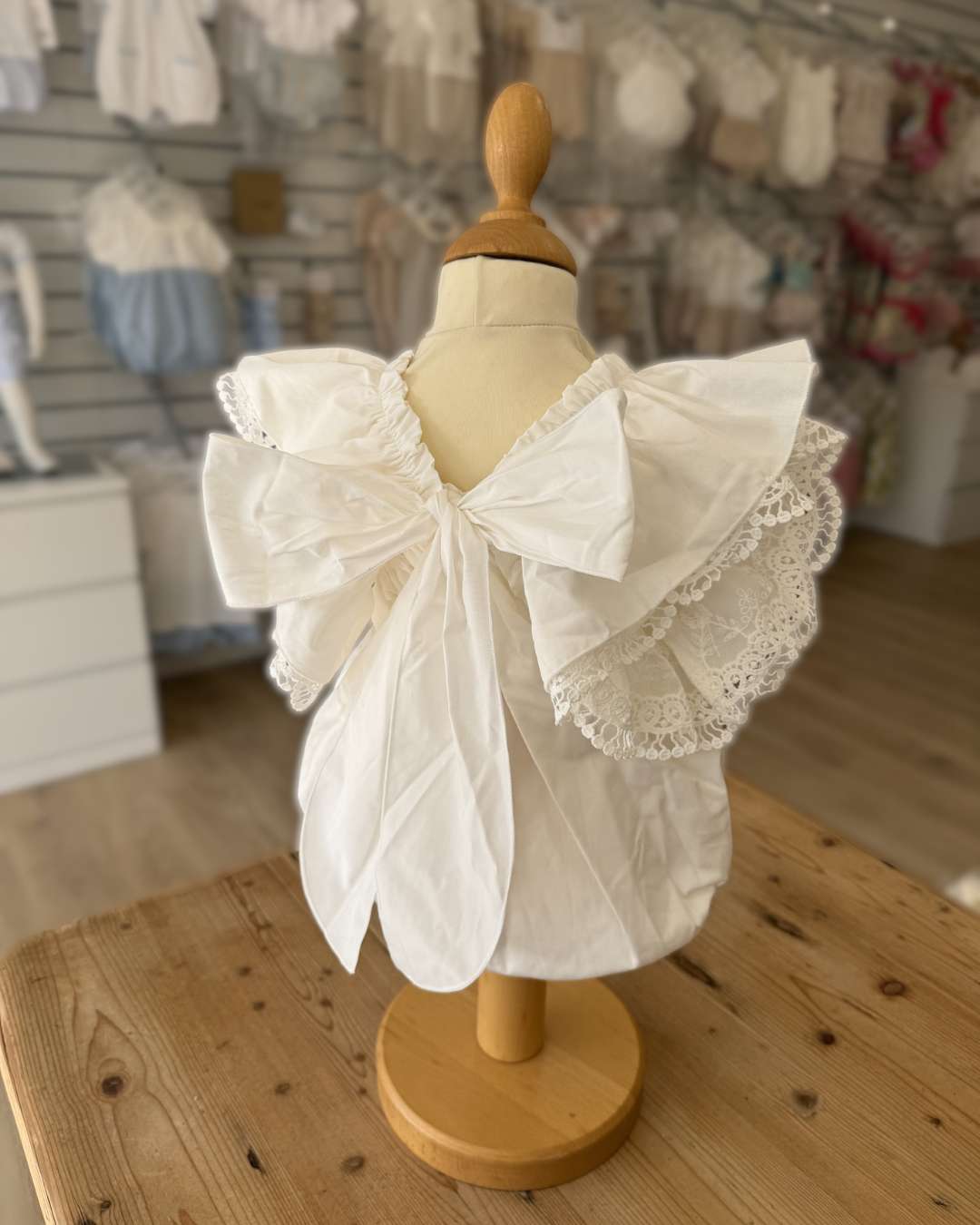 Phi Ivy Bow Back Romper featuring soft ivory cotton, lace-trimmed frill sleeves and an oversized statement bow at the back.