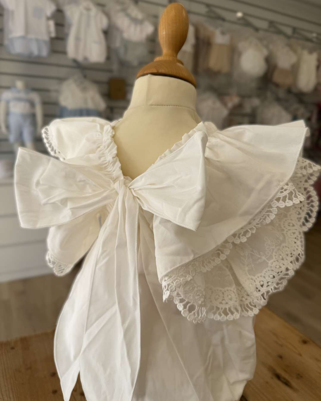 Phi Ivy Bow Back Romper featuring soft ivory cotton, lace-trimmed frill sleeves and an oversized statement bow at the back.