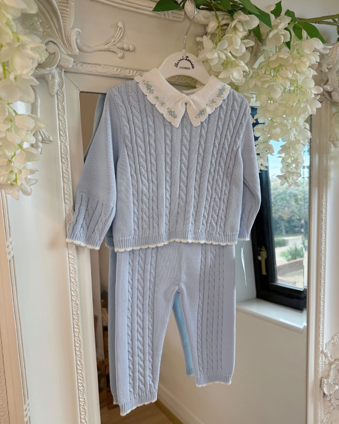 Sarah Louise Aster baby blue knitted trouser set with cable knit detailing and white floral embroidered collar.