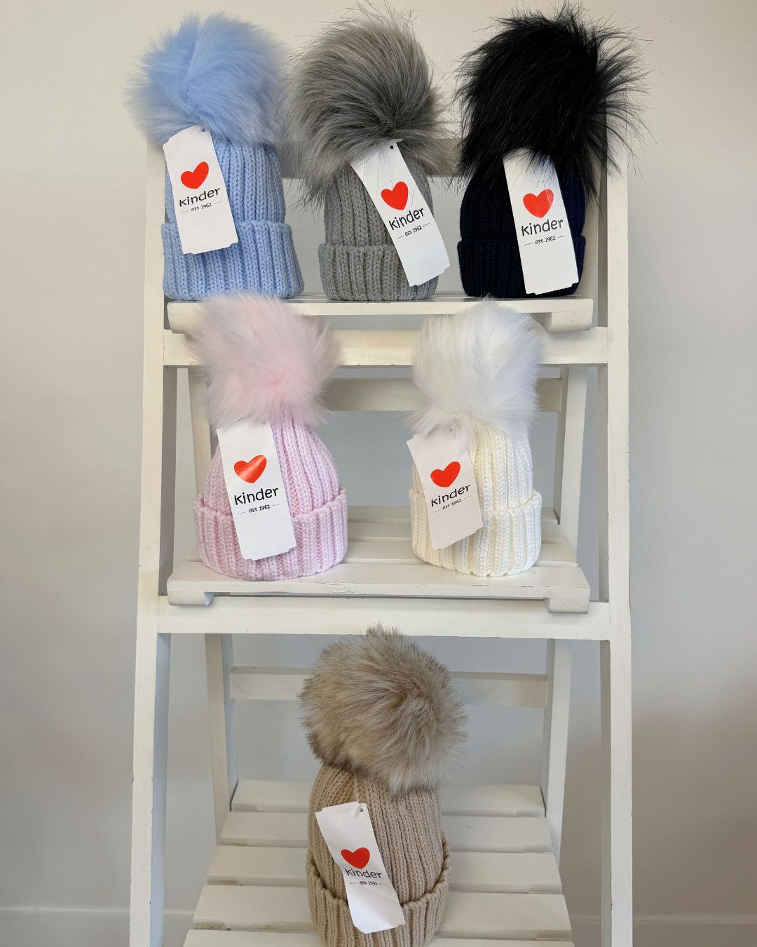 Kinder single faux fur pom knitted hats for babies and children in blue, grey, navy, pink, white and biscuit beige.