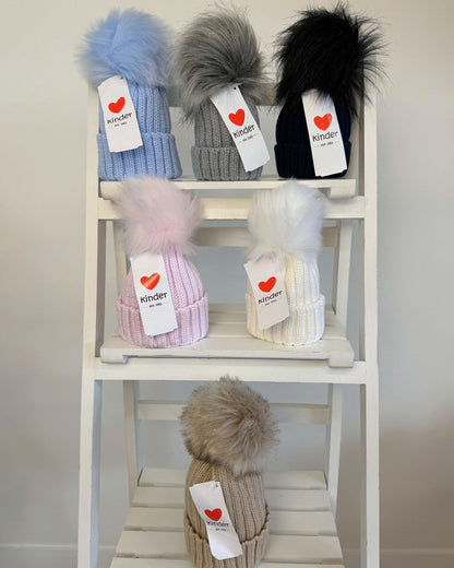 Kinder single faux fur pom knitted hats for babies and children in blue, grey, navy, pink, white and biscuit beige.
