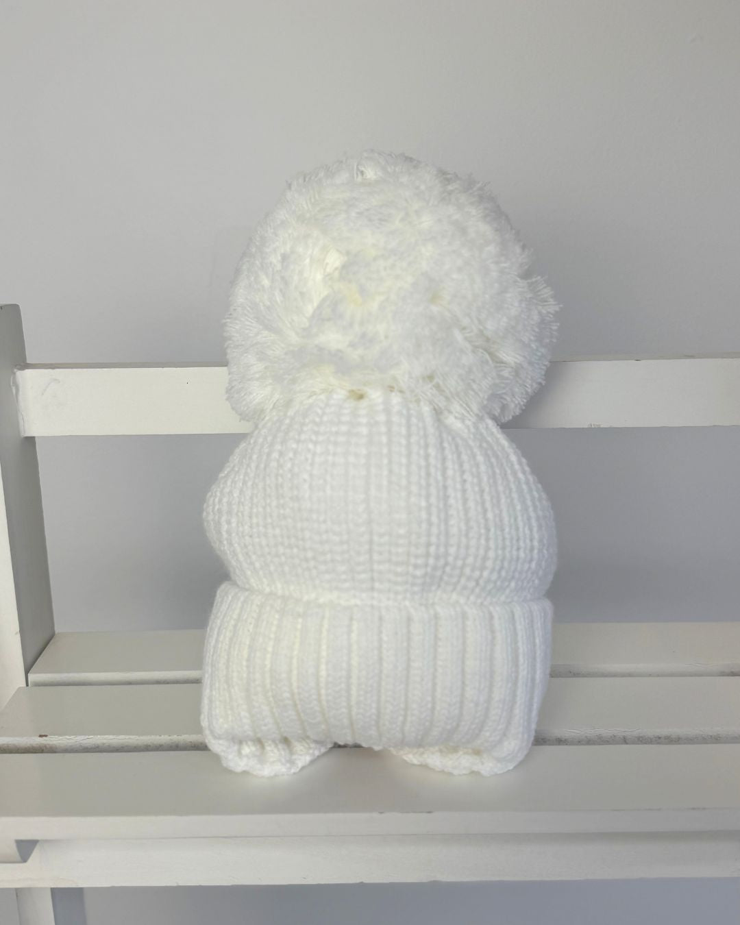 Little Nosh large knitted pom pom baby hat with ribbed turn-up band and cosy ear covers.