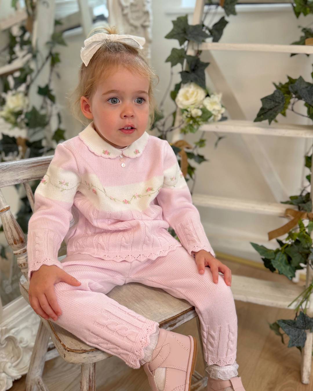 Sarah Louise Madelyn pink knitted girls trouser set with white Peter Pan collar, floral embroidery and cable knit detailing.
