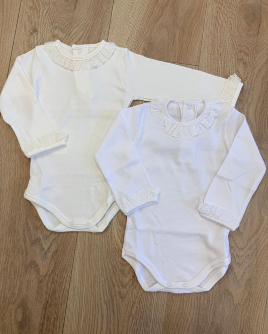Calamaro long sleeve baby girls vest in white and ivory with a delicate broderie anglaise lace frill collar, matching frilled cuffs and popper fastenings.
