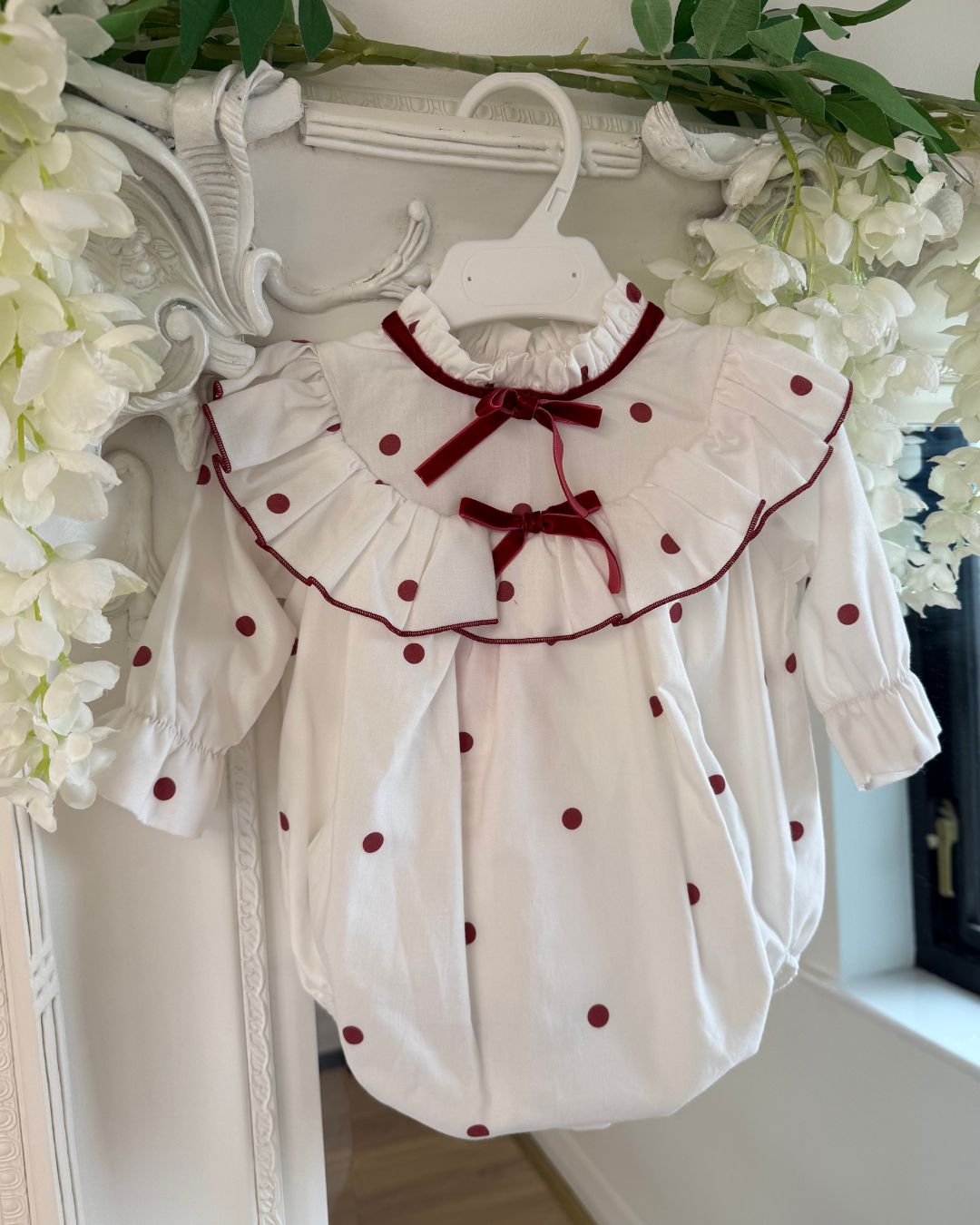 Phi Juliet ivory baby girls romper with red polka dots, frilled collar and red velvet bows.