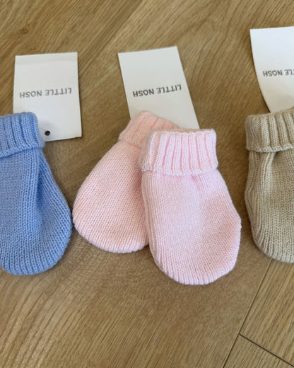 Little Nosh knitted baby winter mittens with turnover cuffs, available in white, pink, biscuit brown and blue.