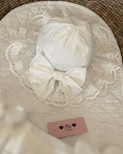 Phi Ivy Lace Sun Hat featuring soft ivory cotton, an embroidered lace brim and a large statement bow for baby girls.