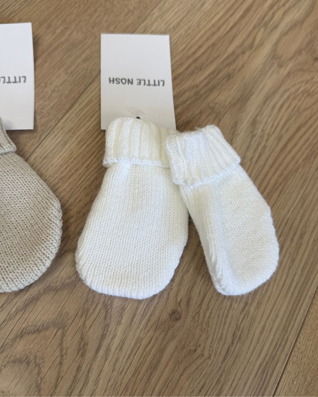 Little Nosh knitted baby winter mittens with turnover cuffs, available in white, pink, biscuit brown and blue.