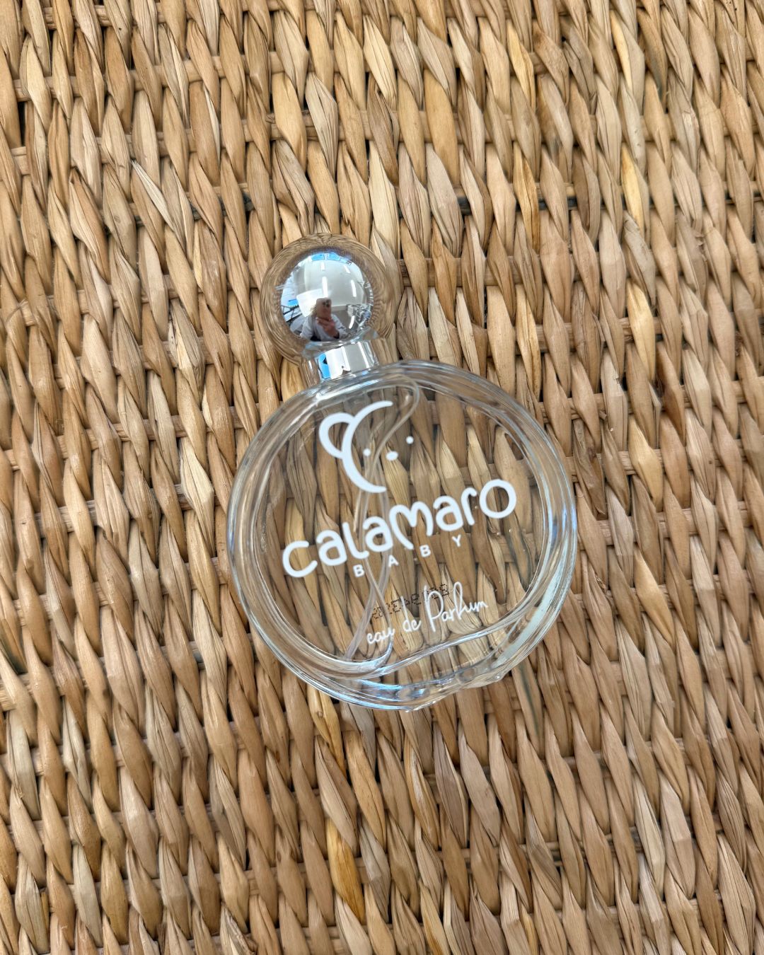 Calamaro Baby Eau de Parfum 60ml in a clear glass perfume bottle with silver lid, presented alongside colourful Calamaro gift packaging.