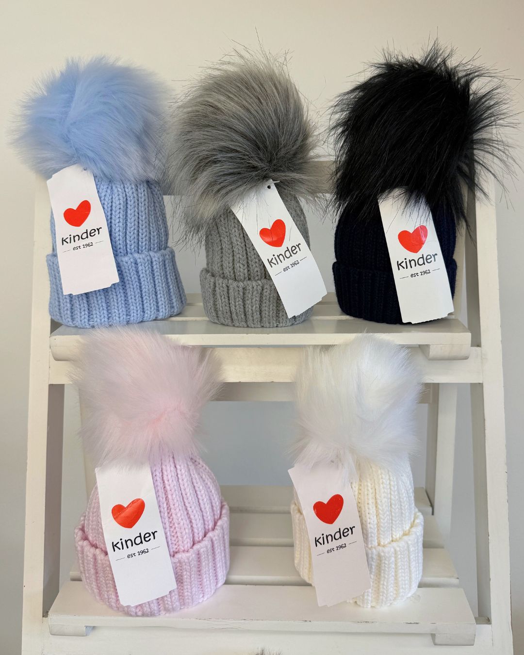 Kinder single faux fur pom knitted hats for babies and children in blue, grey, navy, pink, white and biscuit beige.