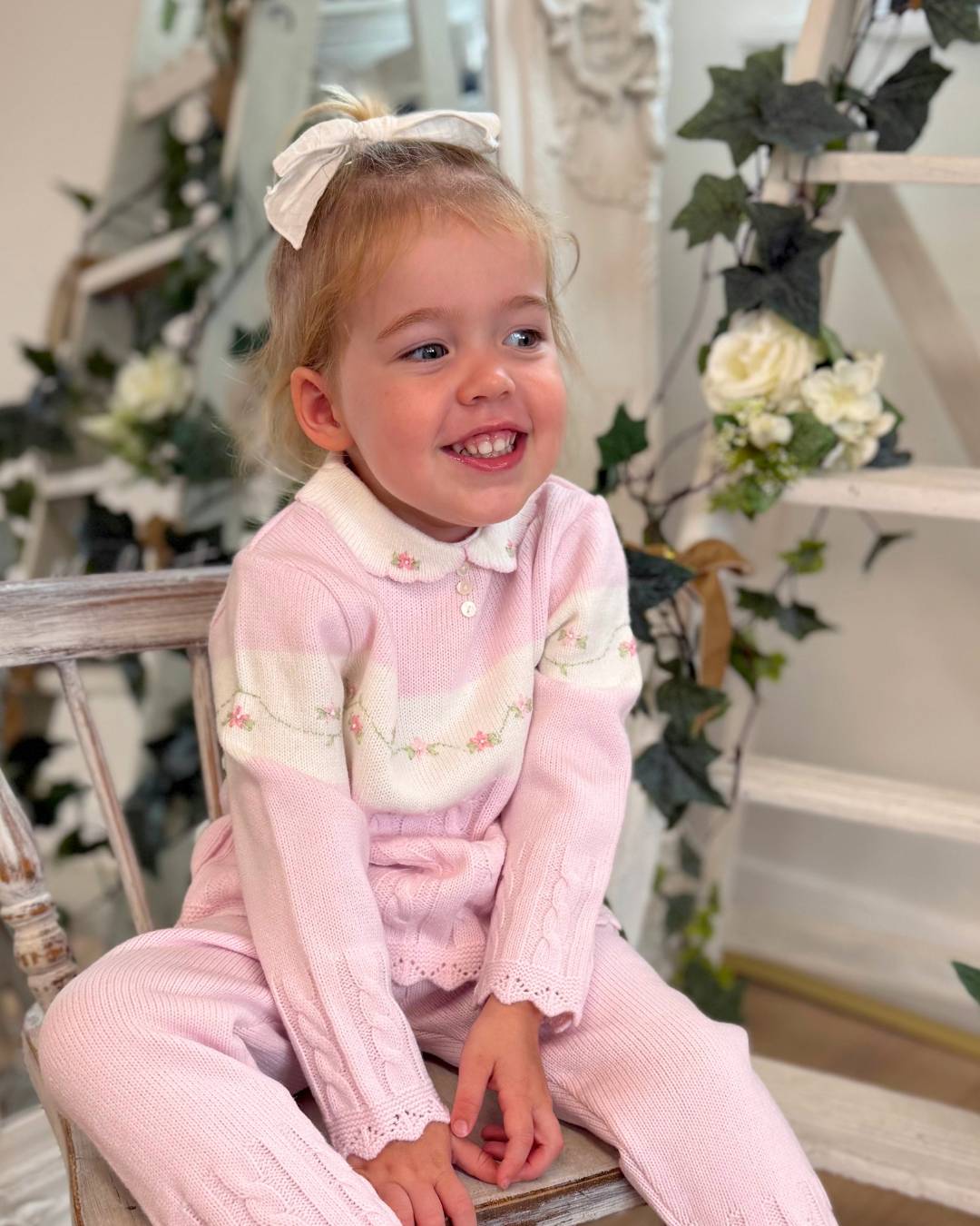 Sarah Louise Madelyn pink knitted girls trouser set with white Peter Pan collar, floral embroidery and cable knit detailing.