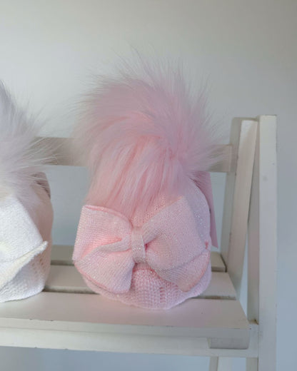 Little Nosh baby girls sparkle knit winter hat in white or pink with faux fur pom pom, oversized side bow and scalloped trim.