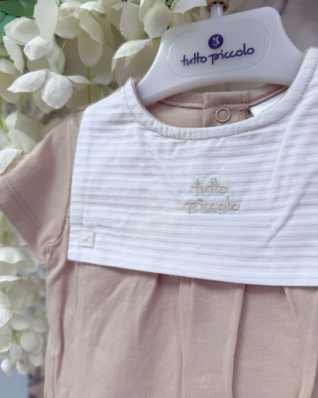 Tutto Piccolo Wren Romper featuring soft beige cotton, a striped bib-style collar, embroidered logo and classic pleated detailing.