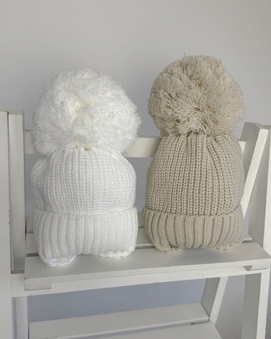 Little Nosh large knitted pom pom baby hat with ribbed turn-up band and cosy ear covers.