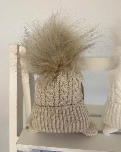Little Nosh Topsy cable knit baby and children’s winter hat with faux fur pom pom, available in white, biscuit brown, blue and navy.