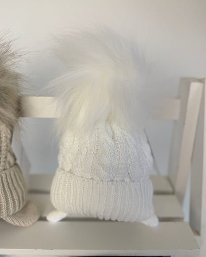 Little Nosh Topsy cable knit baby and children’s winter hat with faux fur pom pom, available in white, biscuit brown, blue and navy.