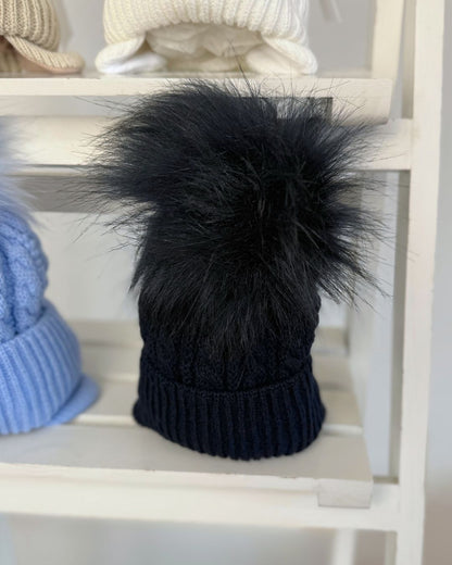 Little Nosh Topsy cable knit baby and children’s winter hat with faux fur pom pom, available in white, biscuit brown, blue and navy.