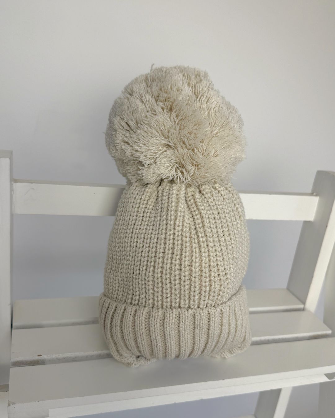 Little Nosh large knitted pom pom baby hat with ribbed turn-up band and cosy ear covers.