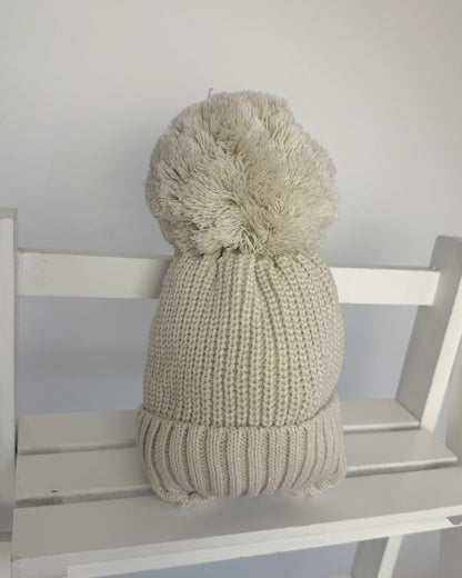 Little Nosh large knitted pom pom baby hat with ribbed turn-up band and cosy ear covers.
