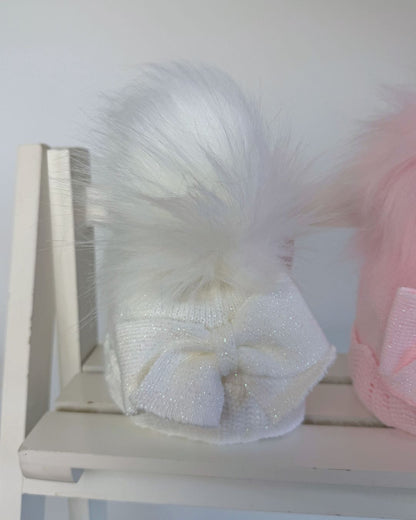 Little Nosh baby girls sparkle knit winter hat in white or pink with faux fur pom pom, oversized side bow and scalloped trim.