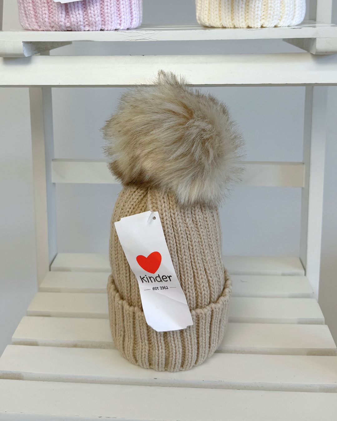 Kinder single faux fur pom knitted hats for babies and children in blue, grey, navy, pink, white and biscuit beige.