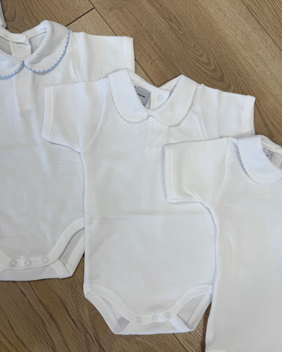 Babidu white unisex baby bodysuit with Peter Pan collar and coloured stitch trim.