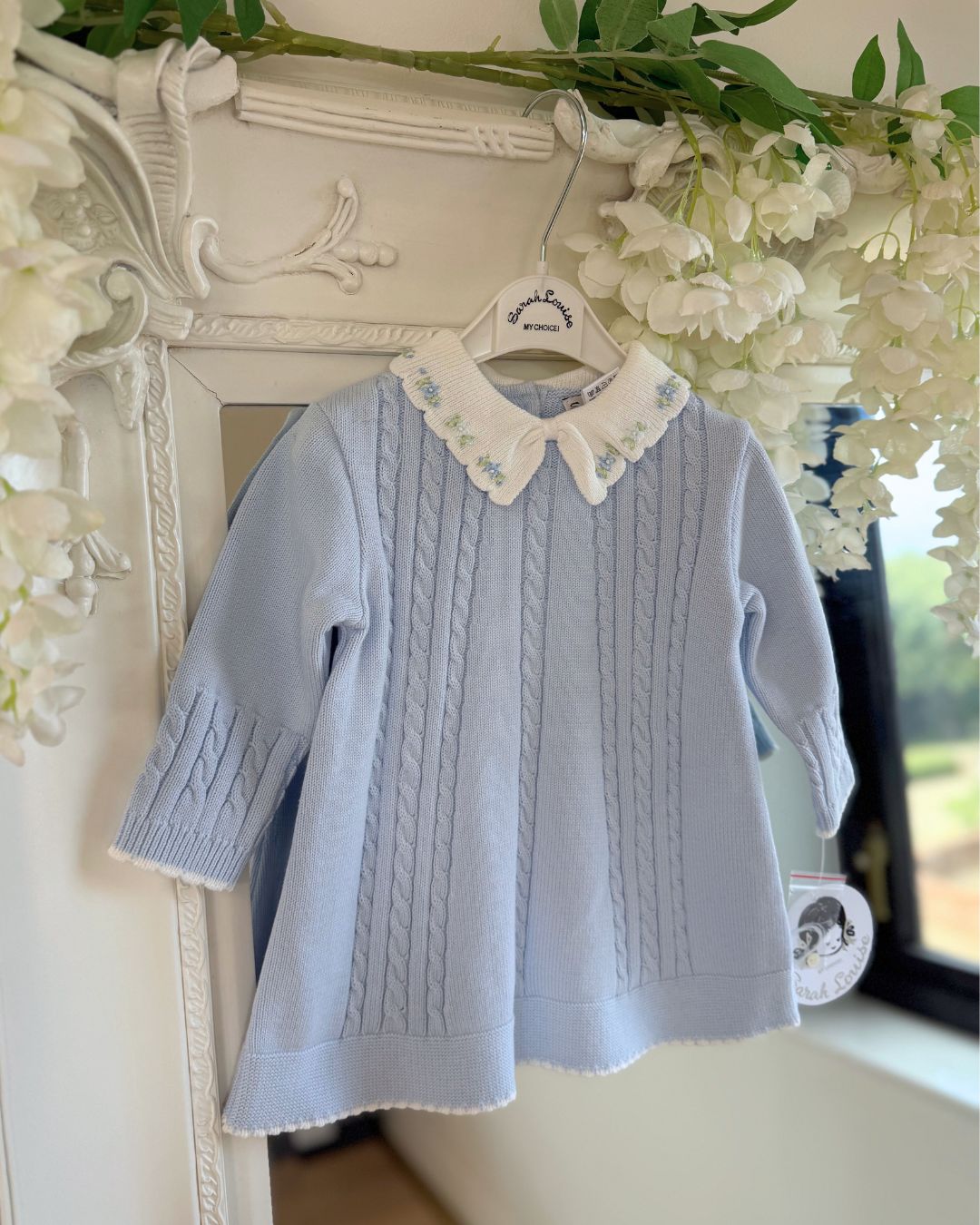 Sarah Louise Aster baby blue girls knitted dress with cable knit detailing, white scalloped floral embroidered collar and bow.