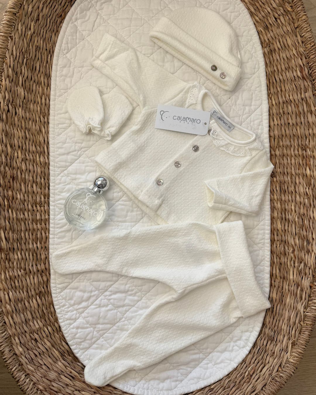 Calamaro Pearl ivory newborn baby girl gift set featuring a lace collar button-up top, matching footed trousers, baby mittens, hat and Calamaro signature baby perfume.