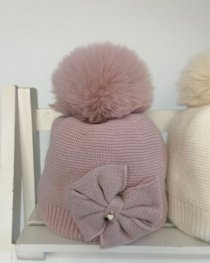 Jamiks Huntley girls knitted bow pom hat with faux fur pom pom, available in cream and dusty pink.