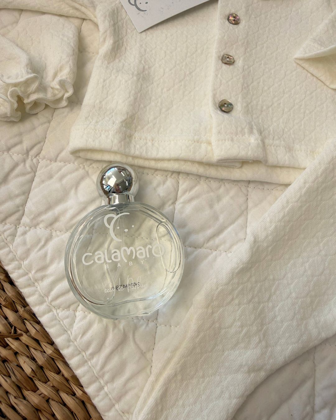 Calamaro Pearl ivory newborn baby girl gift set featuring a lace collar button-up top, matching footed trousers, baby mittens, hat and Calamaro signature baby perfume.