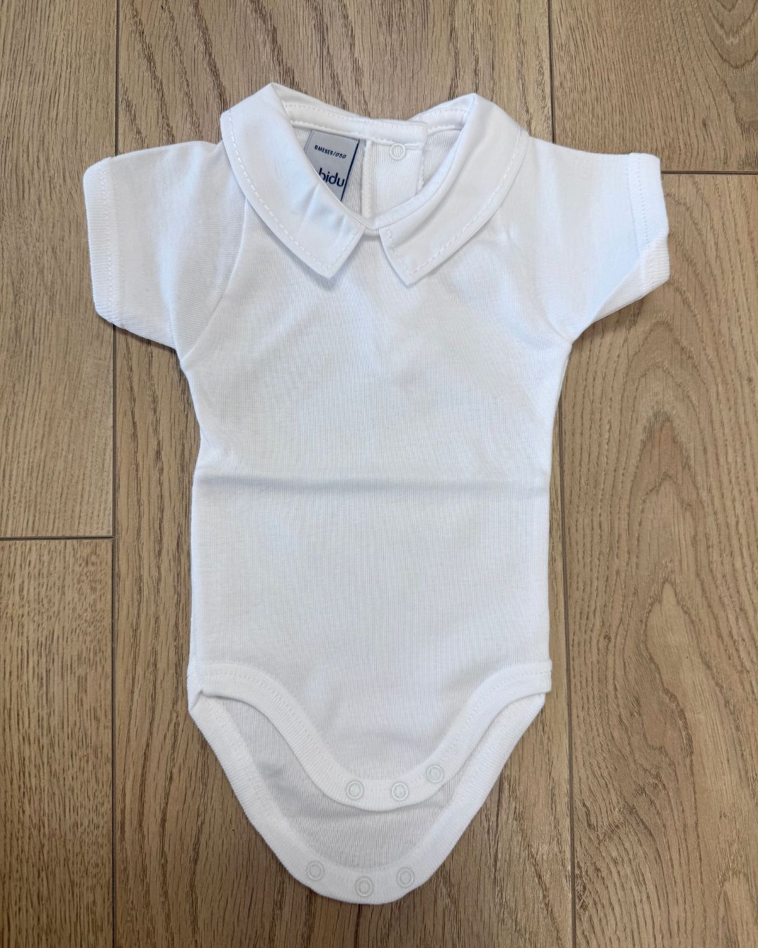 Babidu white short sleeve baby vest with smart pointed white collar.