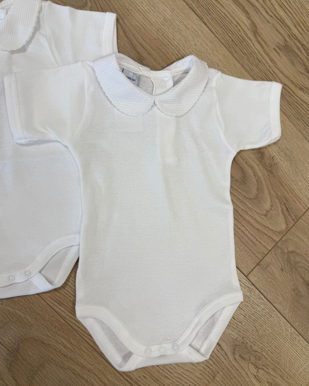 Babidu white unisex baby bodysuit with Peter Pan collar and coloured stitch trim.h