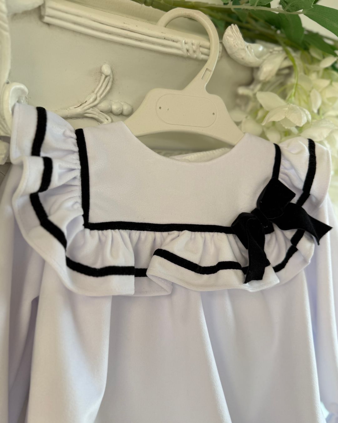 Fofettes X Be Chic Alba white velvet baby girls romper with sailor frill collar, black trim and velvet bow.