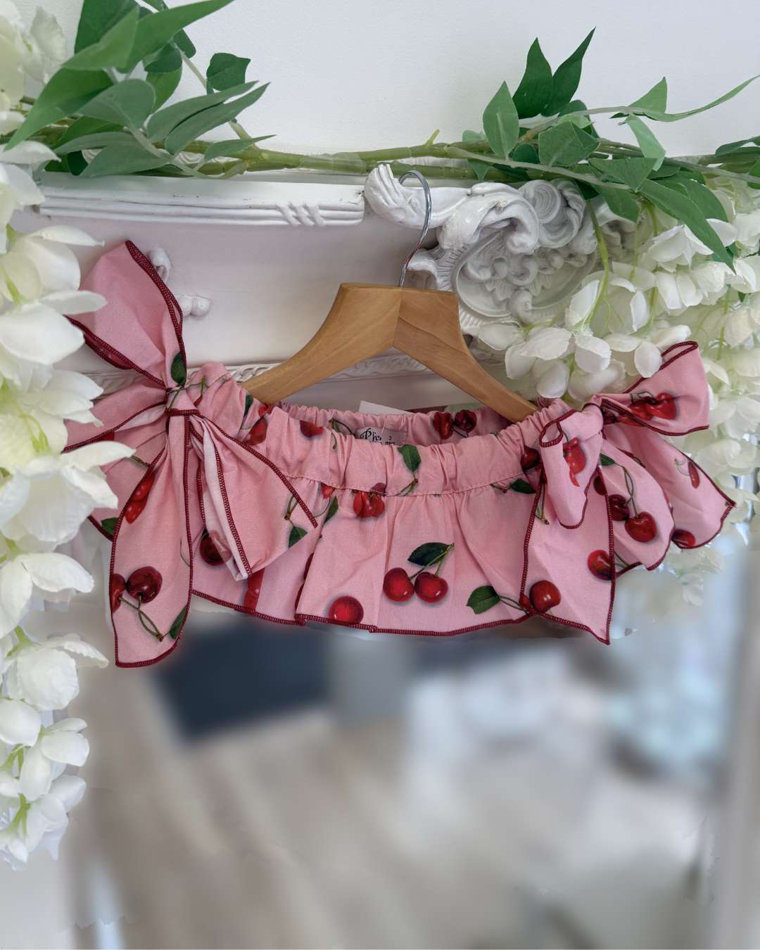 Phi pink jampants with a cherry print, a frill skirt overlay and two large side bows