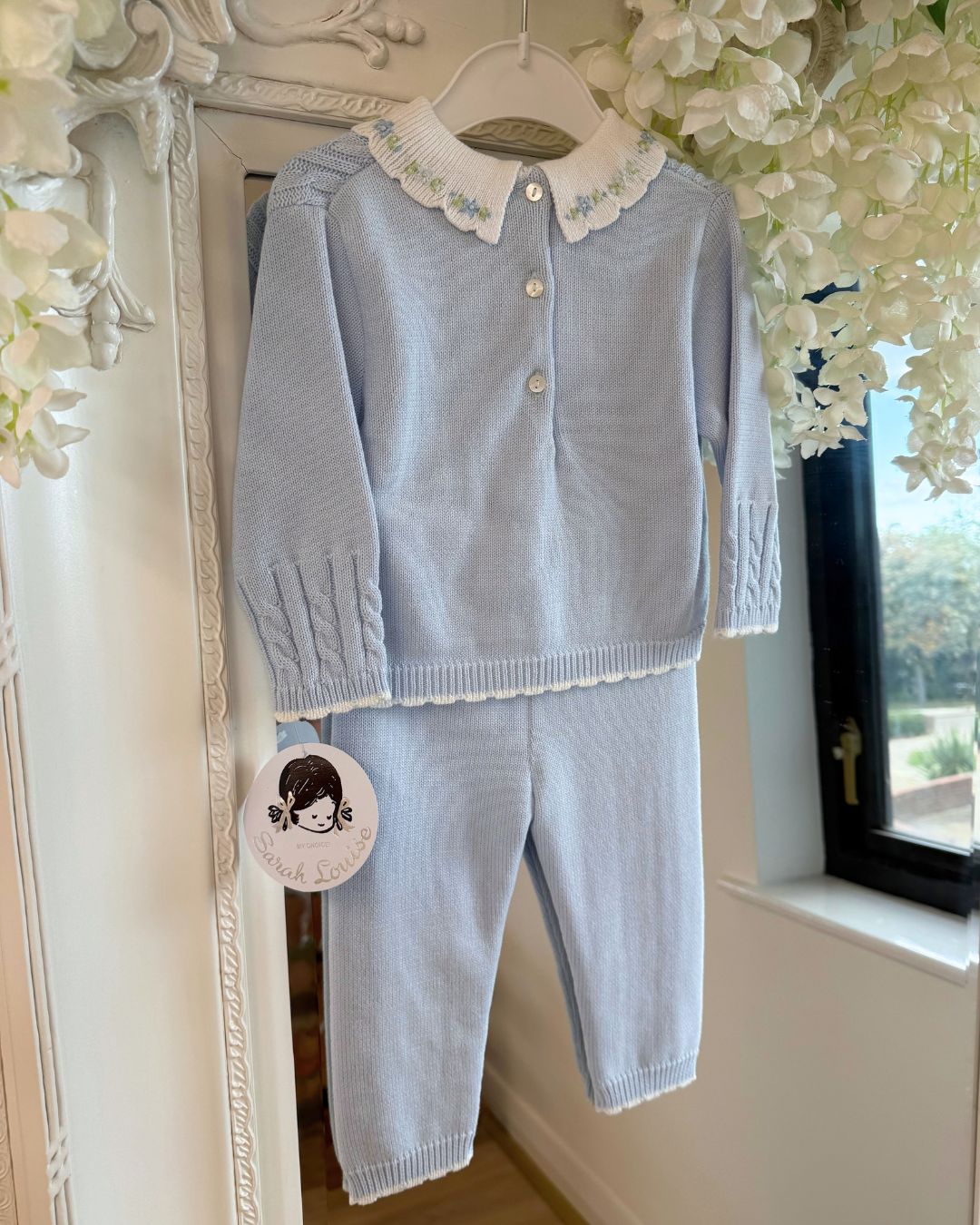Sarah Louise Aster baby blue knitted trouser set with cable knit detailing and white floral embroidered collar.