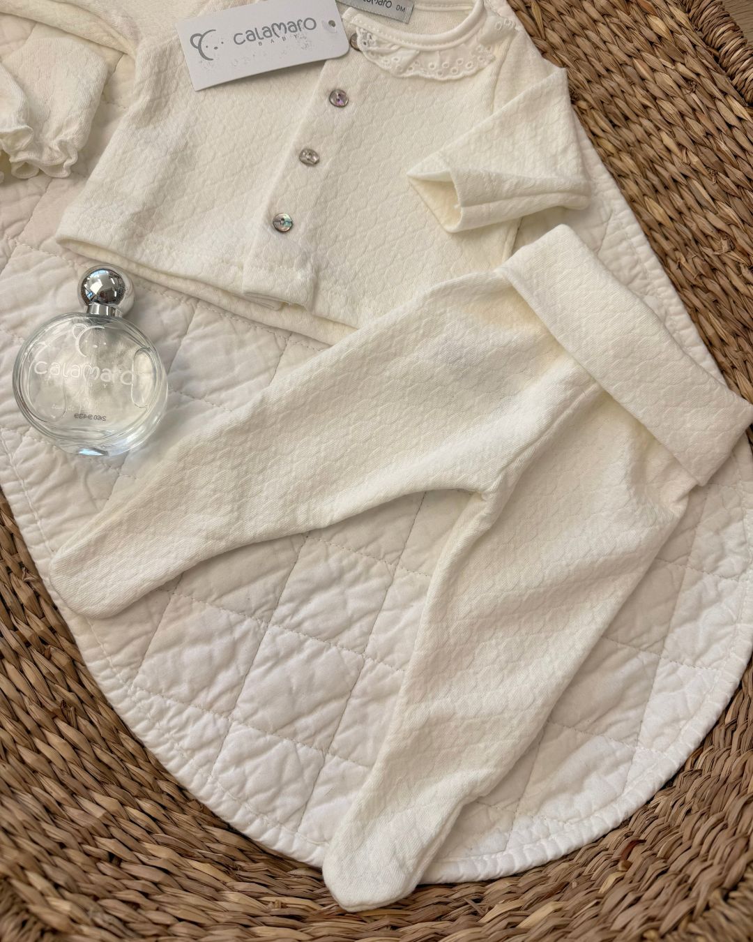 Calamaro Pearl ivory newborn baby girl gift set featuring a lace collar button-up top, matching footed trousers, baby mittens, hat and Calamaro signature baby perfume.