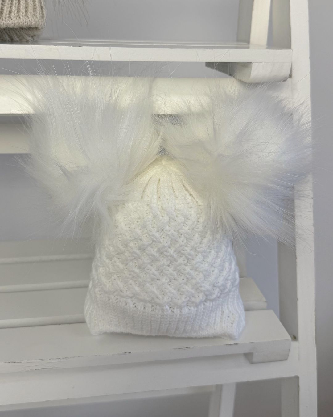 Little Nosh Curly Knit baby winter hat with twin faux fur pom poms, basketweave knit and cosy ear covers.
